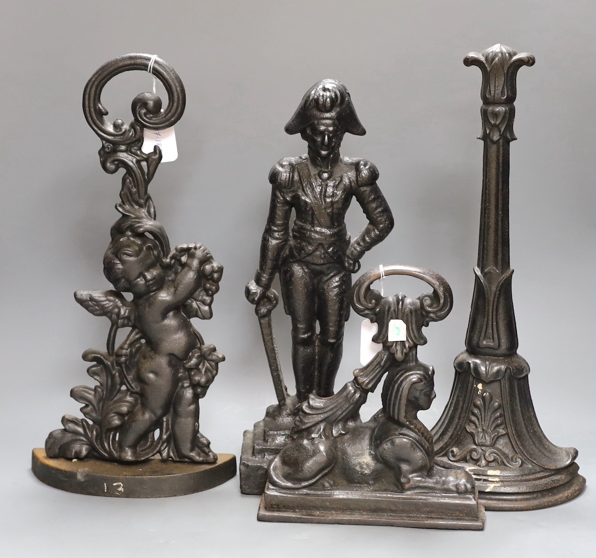 A cherubic cast iron door stop, another of Napoleon, a sphinx and another,(4), Napoleon 40 cms high